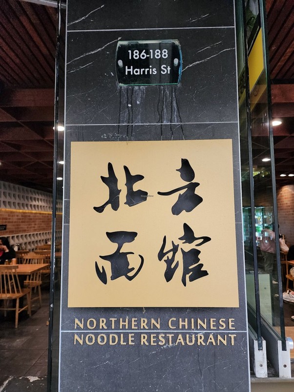 Polished stone entry pillar with 186–188 Harris Street signage